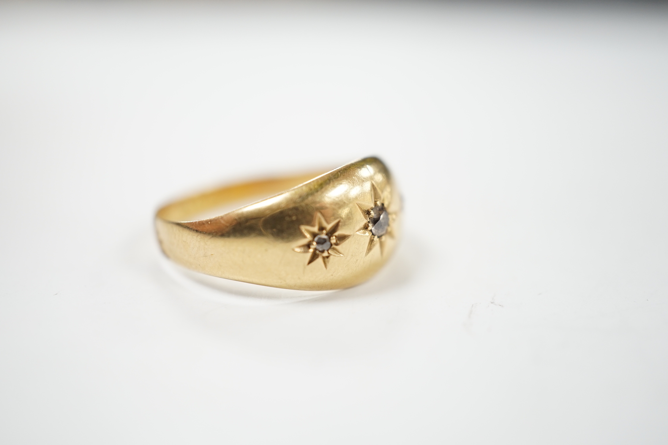 A George V 18ct gold and three stone gypsy set diamond chip set ring, size R, gross weight 3.3 grams.